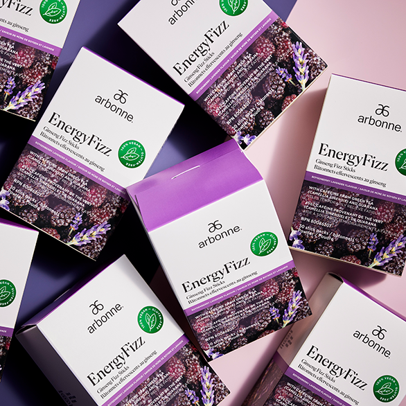 Collection of Arbonne EnergyFizz boxes artistically arranged on a dual-tone background.