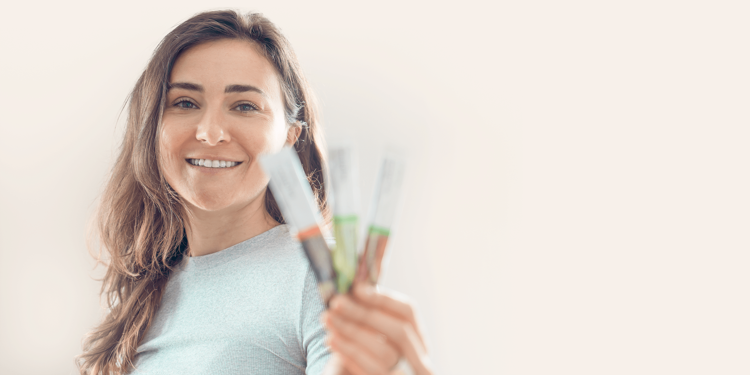 Smiling woman holding Arbonne nutrition energy fizz, promoting a healthy lifestyle.