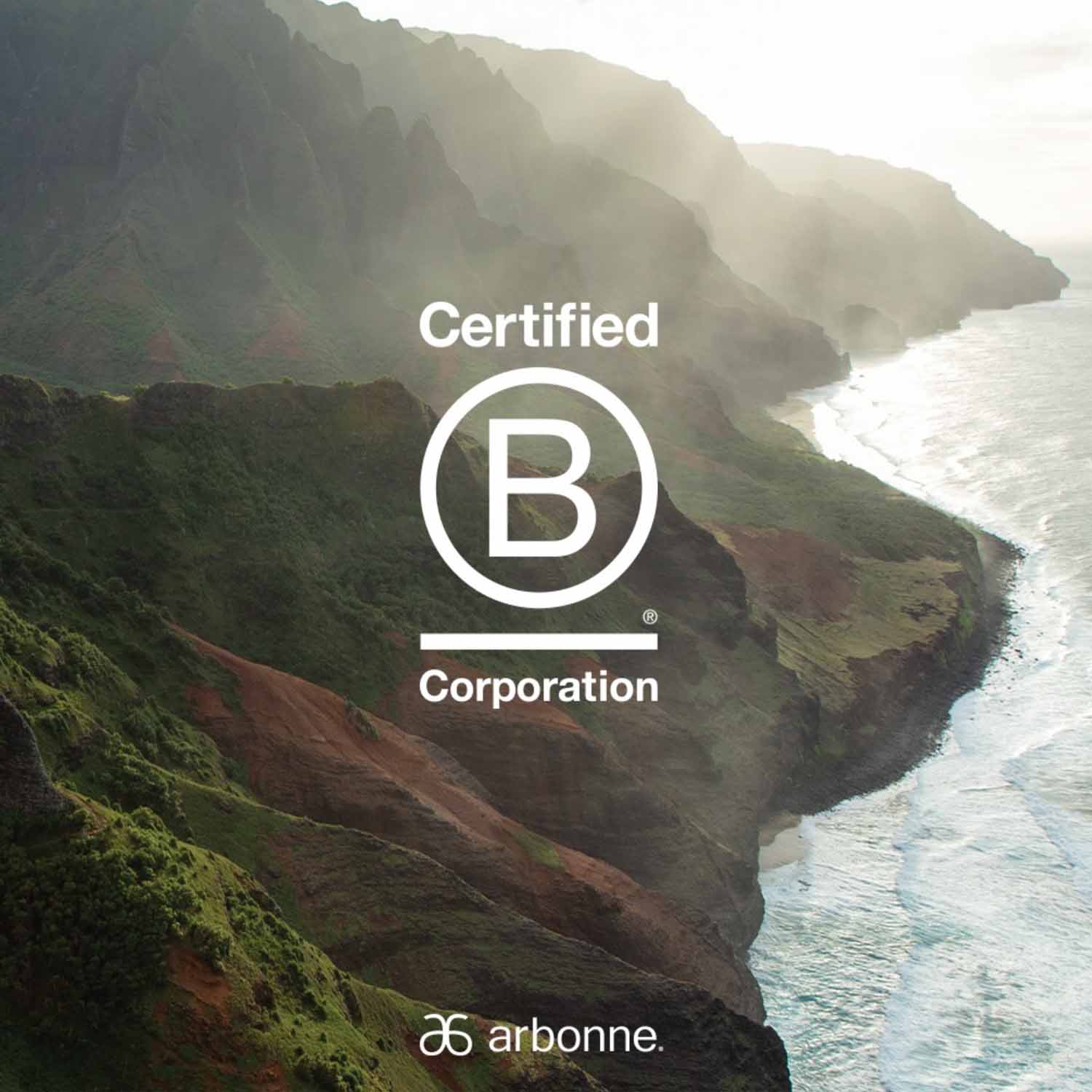 Coastal landscape with Certified B Corporation logo and Arbonne branding, highlighting Arbonne's commitment to sustainability and ethical business practices.