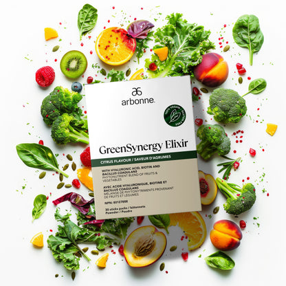 Arbonne GreenSynergy Elixir box surrounded by fresh fruits and vegetables, including oranges, kiwis, raspberries, broccoli, and leafy greens.