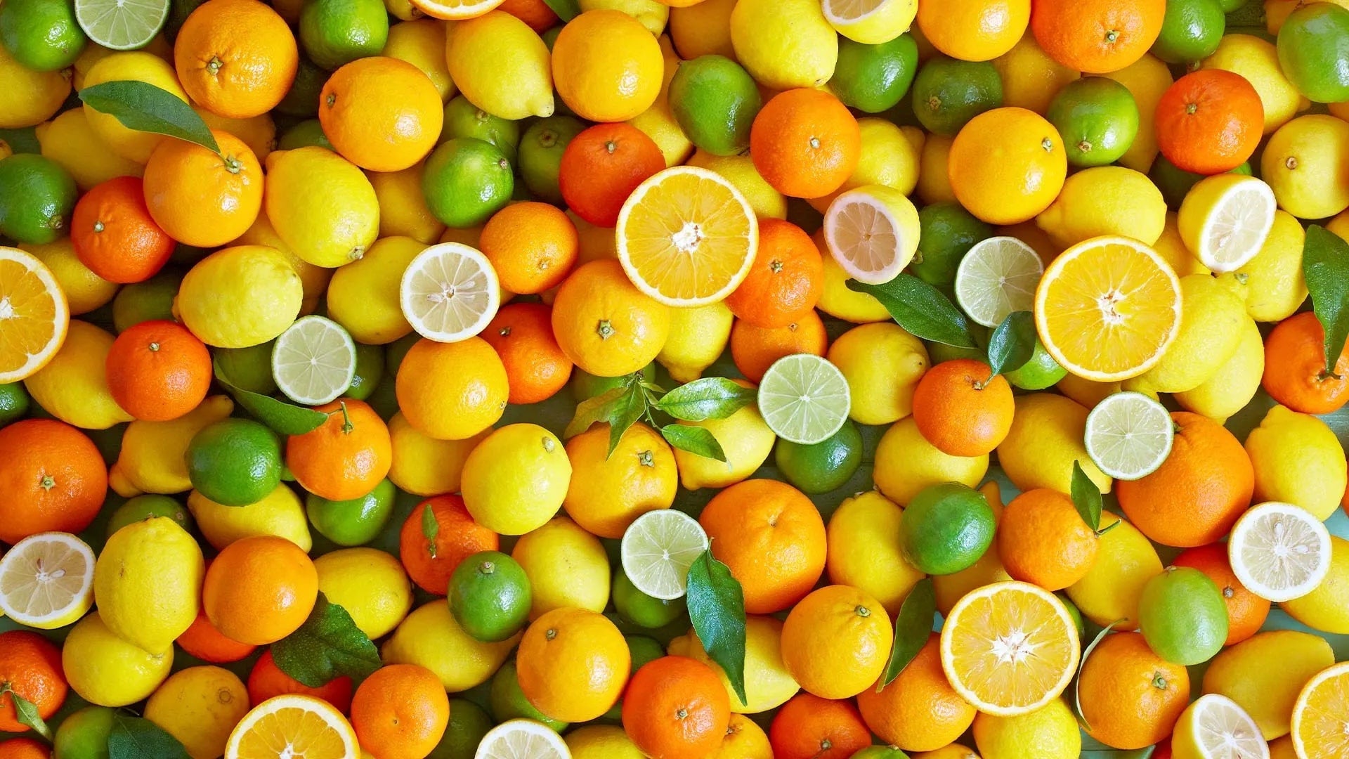 A colorful assortment of citrus fruits including oranges, lemons, limes, and tangerines, showcasing their rich Vitamin C content.